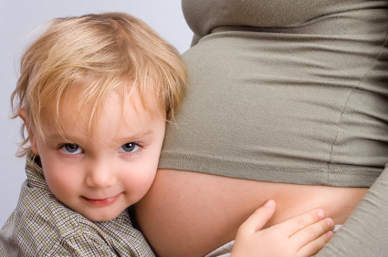Little boy hugging his mother belly.